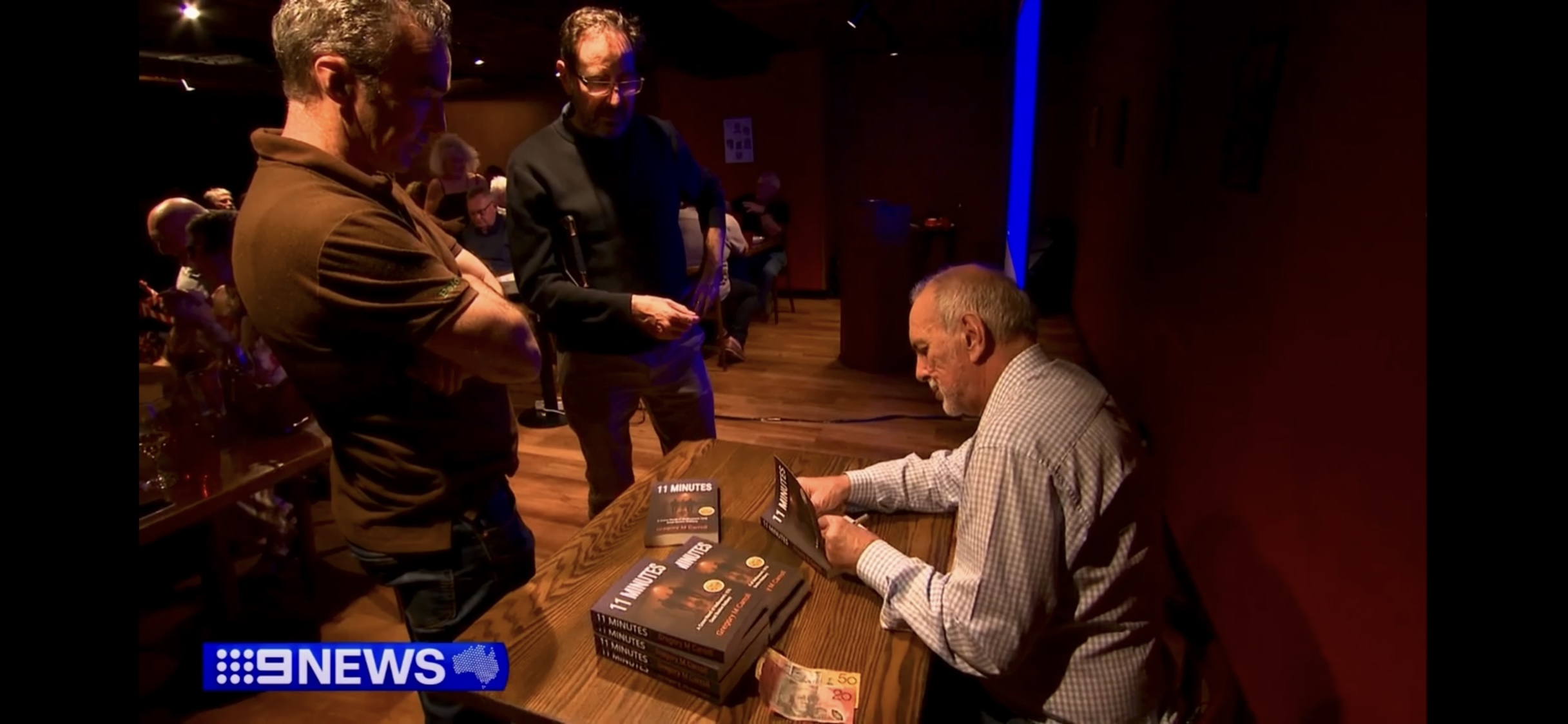 Gregory M Carroll signing copies of 11 Minutes after the 50th anniversary Great Bookie Robbery event